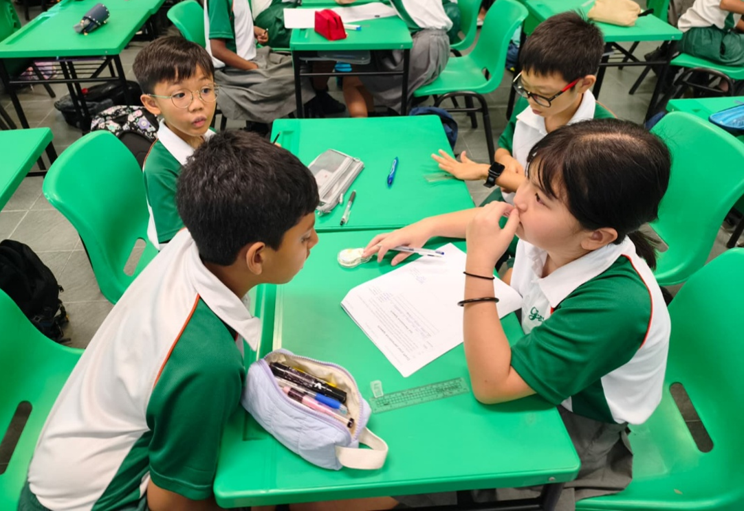 Students collaborating in a small-group classroom discussion.